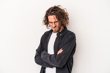 Young caucasian man isolated on white background frowning face in displeasure, keeps arms folded.