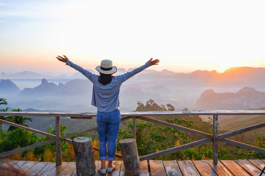 young asia woman feeling happy wearing hat resting on tropical mountain at Doi Ta Pang (khao thalu) travel in chumphon thailand