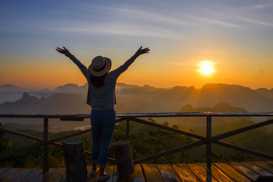 young asia woman feeling happy wearing hat resting on tropical mountain at Doi Ta Pang (khao thalu) travel in chumphon thailand