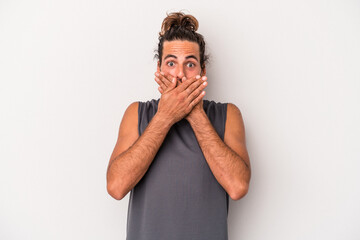 Young caucasian man isolated on gray background shocked covering mouth with hands.