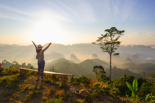 young asia woman feeling happy wearing hat resting on tropical mountain at Doi Ta Pang (khao thalu) travel in chumphon thailand