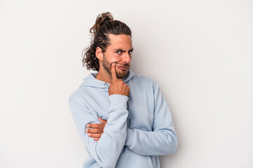 Young caucasian man isolated on gray background unhappy looking in camera with sarcastic expression.