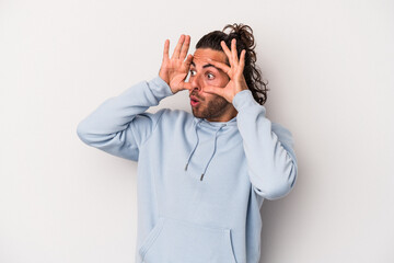 Young caucasian man isolated on gray background keeping eyes opened to find a success opportunity.