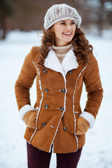 happy elegant female outside in city park in winter