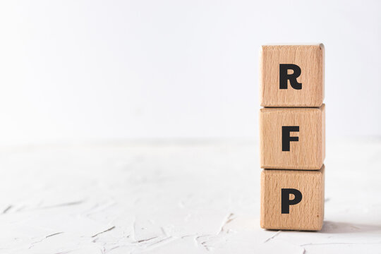Text RFP on wood cubes on white textured putty background. Business and finance concept. Request for proposal.