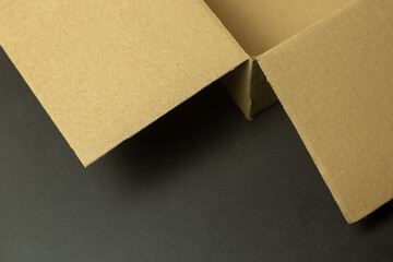 opened shipping box on dark stone background cropped photographed in slightly angled point of view