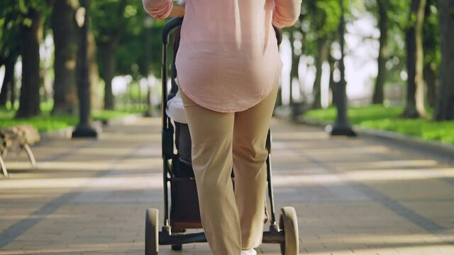 Black female walking with baby pram outdoors, morning routine, healthy habit