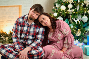 in love and happy man and woman at the Christmas tree.