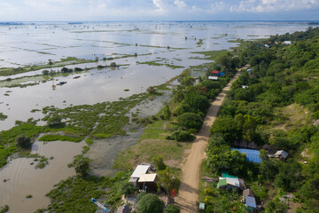 Aerial View of Rice field affected by  Mekong flooding featuring Farm house, silo on dry ground surrounded by flooded fields