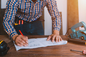 Carpenter working on woodworking machines in carpentry shop.