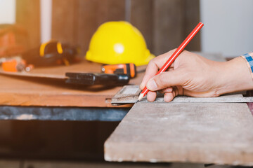 Carpenter working on woodworking machines in carpentry shop.