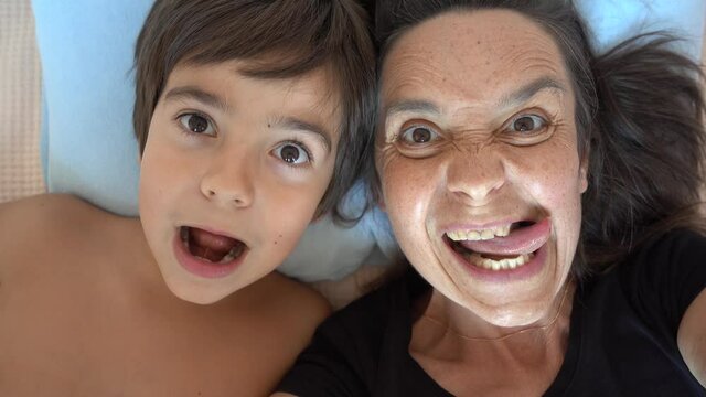 Fethiye, Turkey - 7th of October 2021: 4K Comic mother and son making funny grimaces on camera
