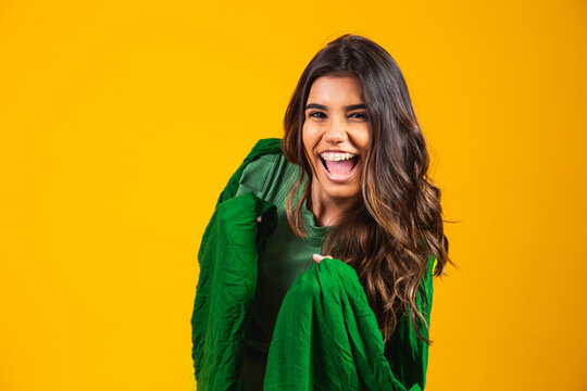 Brazilian supporter. Brazilian woman fan celebrating on soccer or football match on yellow background. Brazil colors..