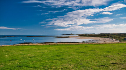 A view of the pristine sands and blue water of the  Northumberland coast in England, UK. Taken on a...