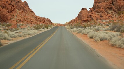 Road trip, driving auto in Valley of Fire, Las Vegas, Nevada, USA. Hitchhiking traveling in America, highway journey. Red alien rock formation, Mojave desert wilderness looks like Mars. View from car.