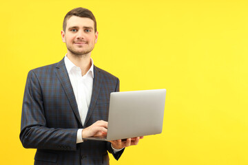 Businessman with laptop on yellow background, space for text