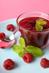 Concept of tasty food with raspberry jam on pink background