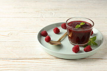 Concept of tasty food with raspberry jam on white wooden background