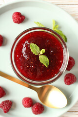 Concept of tasty food with raspberry jam on white wooden background