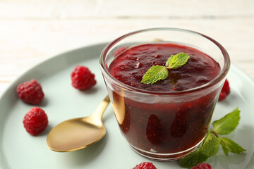 Concept of tasty food with raspberry jam on white wooden background