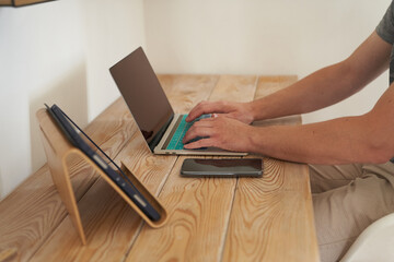 Close-up of a man's hands typing on a keyboard, looking for information. A freelance copywriter is...
