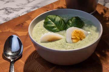 Traditional Finnish cuisines; closeup of a plate of spinach soup with boiled egg and basil topping