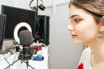 Beautiful young female influencer streaming smiling and talking to her followers online. New technologies, communication, social media, fun, online games.