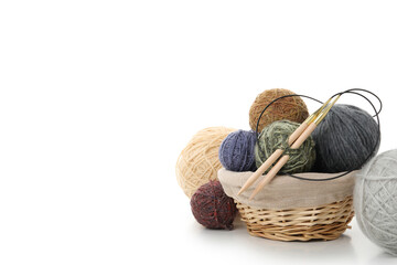 Balls of yarn with knitting needles in basket isolated on white background