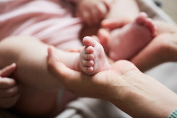 Close-up of mother holding little feet of her newborn child in her hands