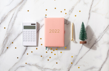 Flat lay composition with New Year's decoration, coral colored 2021 diary book and coffee cup