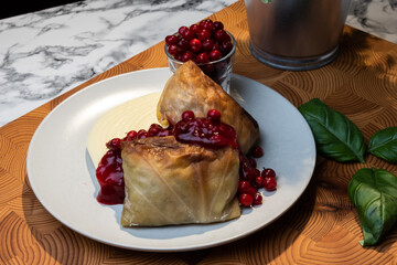 Traditional Finnish cuisines; closeup of a plate of cabbage rolls with mashed potatoes and lingonberry jam.