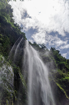 Portrait shot of waterfall against the sky