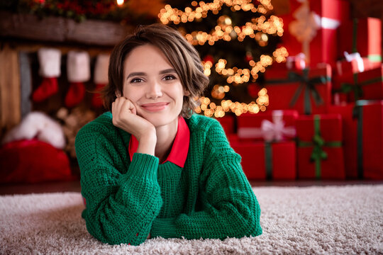 Photo of charming cute young lady wear green pullover smiling lying floor arm cheek indoors house home room