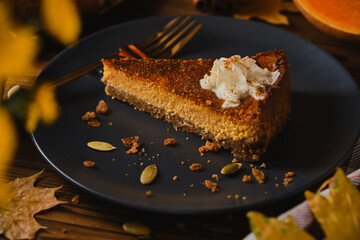 Homemade pumpkin cheesecake decorated with whipped cream.
