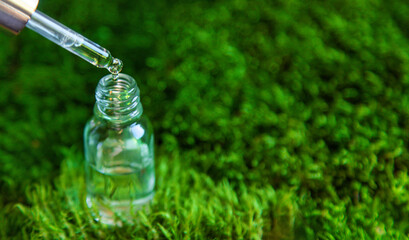 Cosmetics in a bottle and essential oils on moss. Natural spa. Selective focus.