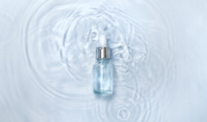 Cosmetics in a bottle in water, skin hydration concept. Hyaluronic acid. Selective focus.