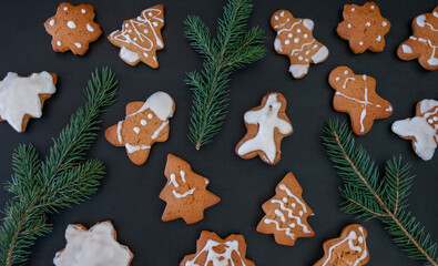 Happy New Year's set of gingerbread from ginger biscuits glazed sugar icing decoration on black background, minimal seasonal pandemic winter holiday banner