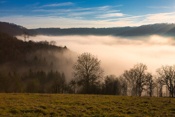 Fototapeta na wymiar Beautiful scenic winter landscape with a fog filled valley