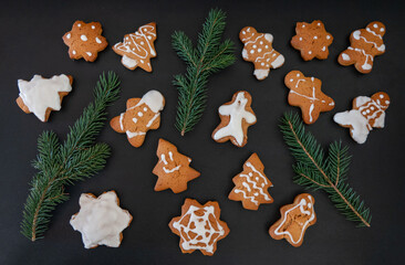 Obraz na płótnie Canvas Happy New Year's set of gingerbread from ginger biscuits glazed sugar icing decoration on black background, minimal seasonal pandemic winter holiday banner