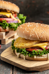 Two delicious homemade burgers of beef, cheese and vegetables. Fat unhealthy food. vertical image. place for text