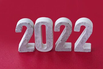 concrete numbers 2022 on burgundy background..