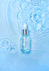 Cosmetics in a bottle in water, skin hydration concept. Hyaluronic acid. Selective focus.