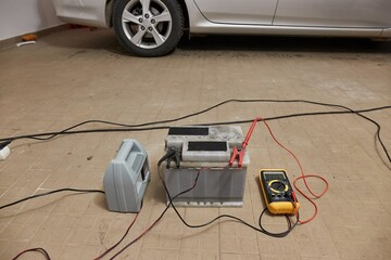 Charging a car starter battery in a garage
