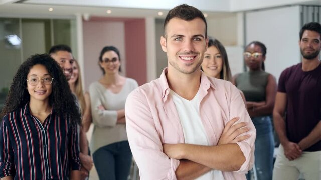 Video of successful business team posing for presentation of work while looking at camera in a coworking space.