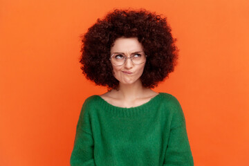 Portrait of confused woman with Afro hairstyle wearing green casual style sweater and optical...