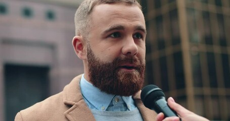 Close up of successful bearded caucasian businessman standing on street and giving interview to reporter answering questions in microwave.