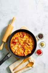 pizza in pan,Fresh raw pizza with mushrooms, cherry tomatoes , Basil and Parmesan in a round pan on a white background with copy space. Homemade pizza before baking