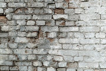 Gray old textured brick wall with cracks for background