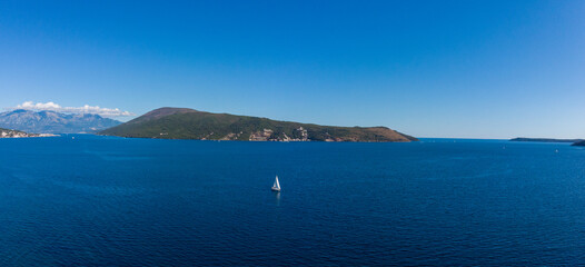 Sailing yacht sails along Bay of Kotor in Montenegro,Adriatic sea.