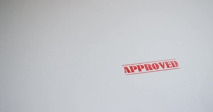 A stamp Approved is placed on a sheet of white paper, copyspace compocition